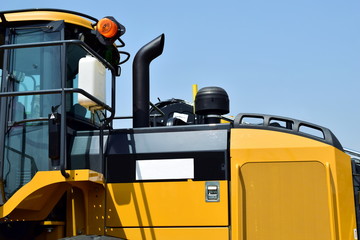 Logging machine. Close-up of the tractor cab. Yellow-black color heavy machines.