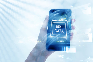 Woman Hand holding mobile phone. Server room background. Inscription on a virtual screen: Big Data. Double exposure.