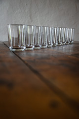 Reihe von leeren Gläsern auf einem Holztisch (Vertikal)