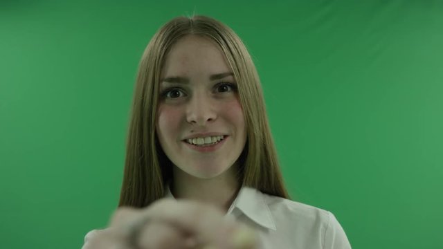 A business woman scrolling through a virtual display in front of a green background. - Powered by Adobe