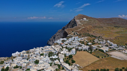 Fototapeta na wymiar Aerial drone photo of picturesque main village (chora) of Folegandros island featuring uphill church of Panagia (Virgin Mary) built on top of steep hill overlooking the Aegean sea, Cyclades, Greece