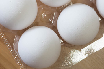 Bunch of white eggs in a plastic transparent tray from the supermarket. Close up shot.