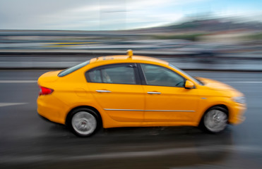 Obraz na płótnie Canvas Evening traffic long exposure yellow turkish taxi car on istanbul 