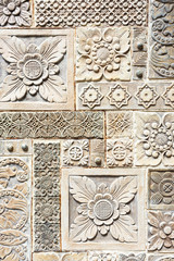 Close up antique balinese fresco with flowers and pattern from white stone in Garuda Wisnu Park at Bukit, Bali, Indonesia.