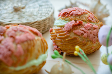 Homemade tasty profiteroles with pistachio cream, selective focus. Craquelin Choux Buns