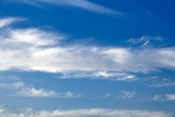 Naklejka na ściany i meble White sparse clouds over blue sky