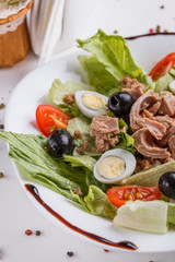 Fresh salad with iceberg lettuce,tomatoes,eggs,canned tuna and olives