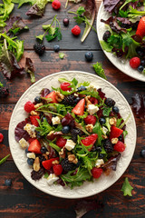 Fresh Fruit Salad with blueberry, strawberry raspberry, walnuts, feta cheese and green vegetables. healthy summer food
