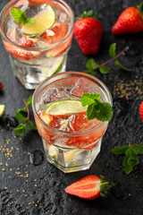 Strawberry Mojito cocktail with Rum, lime and mint in glass. Summer cold drink with ice