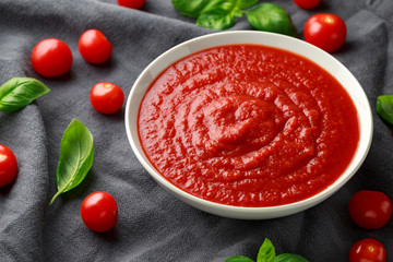 Homemade tomato Passata in white bowl with basil