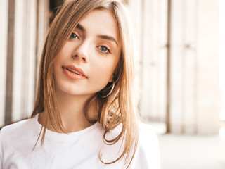 Portrait of beautiful smiling blond model dressed in summer hipster clothes. Trendy girl posing in the street background. Funny and positive woman having fun