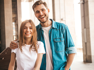 Portrait of smiling beautiful girl and her handsome boyfriend. Woman in casual summer jeans clothes. Happy cheerful family. Female having fun on the street background.Looking at each other