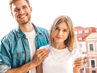 Portrait of smiling beautiful girl and her handsome boyfriend. Woman in casual summer jeans clothes. Happy cheerful family. Female having fun on the street background.Looking at each other