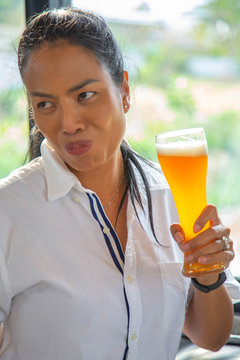 Close up image Professional bartender or happiness beautiful Asian woman pouring beer from bottle into a glass congratulation relax time alcoholism concept