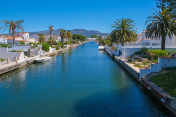 Fototapeta na wymiar Amazing view on marine canal with boats and houses. Resort town landscape with palm trees, little Spanish Venice, Empuriabrava. Rich lifestyle, Summer time.