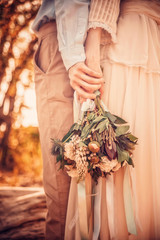 bride and groom with wedding bouquet of flowers
