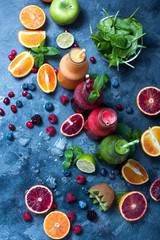 Colorful detox smoothie in bottles, summer diet fresh drink, red, green, yellow smoothie with...