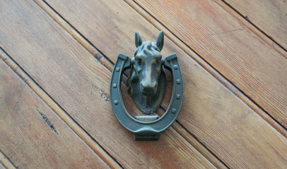 Horseshoe and horse head brass decoration on an old door