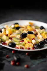 fresh organic sliced or chopped in a small pieces exotic fruits, garnet, kiwi, bananas