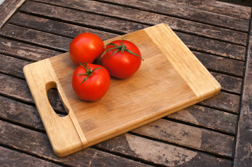 3 tomates sur planche de cuisinier