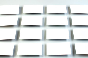 Mockup of horizontal business cards stacks arranged in rows at white textured paper background.