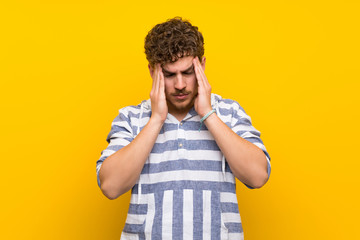 Blonde man over yellow wall unhappy and frustrated with something