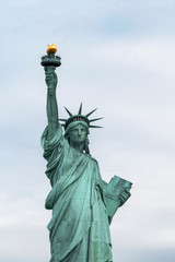 Fototapeta na wymiar USA, New York - May 2019: Statue of Liberty, Liberty Island against an overcast sky