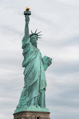 Naklejka na ściany i meble USA, New York - May 2019: Statue of Liberty, Liberty Island against an overcast sky