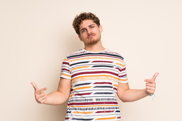 Fototapeta premium Blonde man over isolated wall proud and self-satisfied