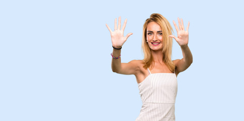 Fototapeta na wymiar Young blonde woman counting ten with fingers over isolated blue background