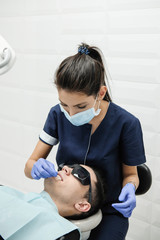 Womans dentist working in the dental office.