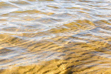 Sandy lake bottom in crystal clear water in summer on a bright Sunny day.