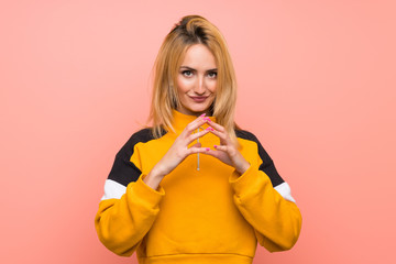 Young blonde woman over isolated pink background scheming something