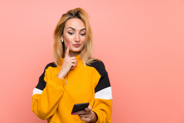 Young blonde woman over isolated pink background thinking and sending a message