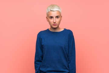 Teenager girl with white short hair over pink wall with sad and depressed expression