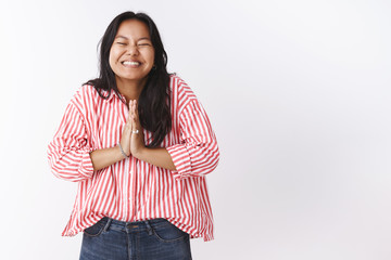 Excited girl cannot wait wish come true smiling joyfully with closed eyes holding hands in pray,...