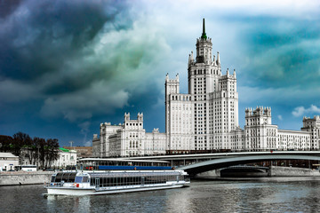 Fototapeta premium Moscow, Russia - Kotelnicheskaya Embankment Building, an apartment building in Moscow. Cityscape with Moscow-river. Pleasure boat.