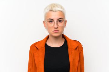 Teenager girl with short hair over white wall sad