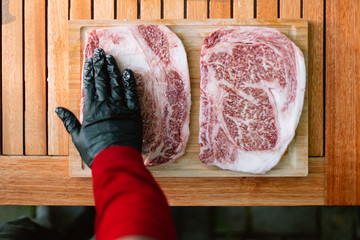 human hand seasoning two wagyu kobe steaks with salt