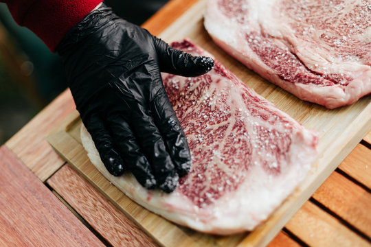 human hand seasoning two wagyu kobe steaks with salt