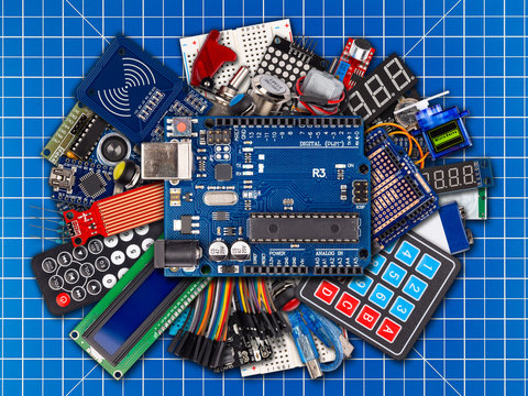 collage of microcontroller board display sensor button switches cable wire accessories and equipment blue cutting matte workplace electronics concept background