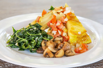 Spanish Potato Tortilla served with mushrooms and spinach, casual dining restaurant food