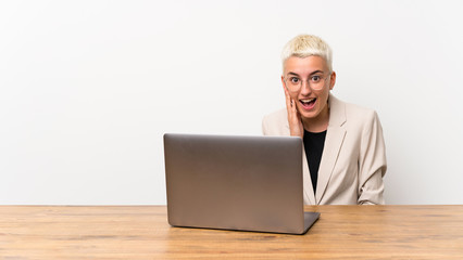 Teenager girl with short hair with a laptop with surprise and shocked facial expression