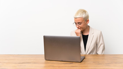 Teenager girl with short hair with a laptop having doubts