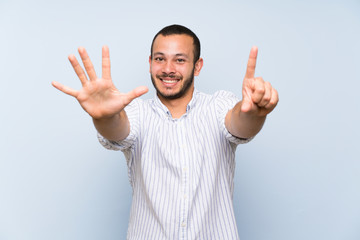 Colombian man over isolated blue wall counting six with fingers