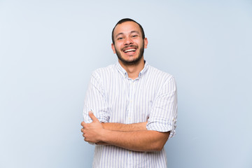 Colombian man over isolated blue wall smiling