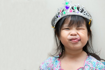 Close-up portrait of cheeky cheerful hilarious emotional cute attractive charming girl wearing crown.