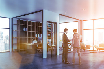 Two men in office lobby with manager office