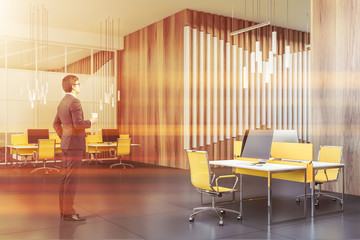 Man with coffee in wooden open space office