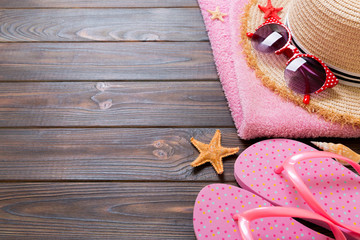 Straw hat, pink flip flops, towel, sunglasses and starfish On a white wooden background. top view summer holiday concept with copy space